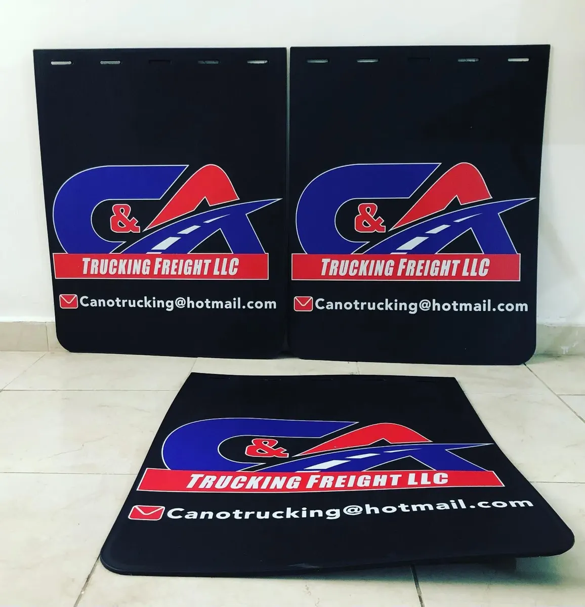 Juego de loderas negras con logotipo azul y rojo de empresa de transporte y correo de contacto