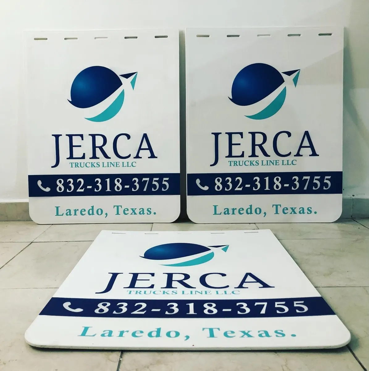 Loderas blancas de línea de transporte de Laredo con logotipo y teléfono en franja azul